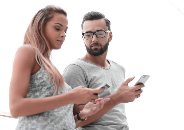 Młoda para patrząc na ekranach swoich smartfonów - Zdjęcie, obraz