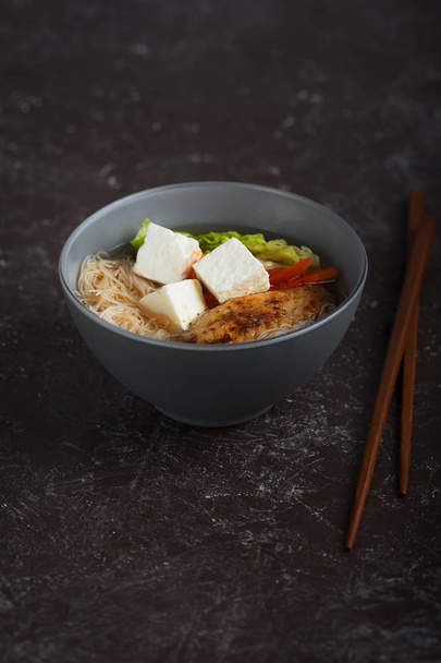 Tradycyjne pikantna zupa Azjatycka z serem tofu i makaron. To danie zawiera zwykle bulionu i warzywa. Orientacja pionowa - Zdjęcie, obraz