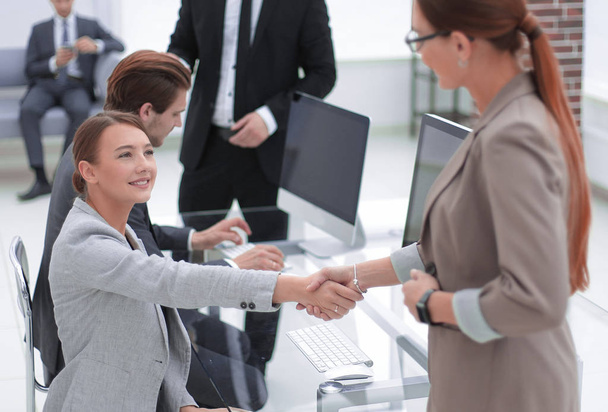handshake two business women near the desktop - Фото, изображение