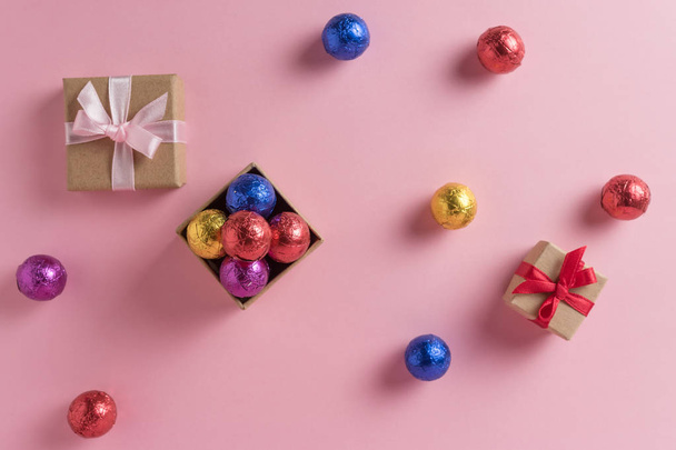 Creative layout of colored candy and gift box on pink background. Minimal holiday concept. - Foto, afbeelding