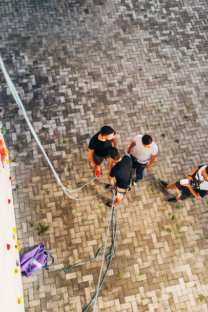 Groupe d'amis se préparent à grimper sur un mur artificiel - Photo, image