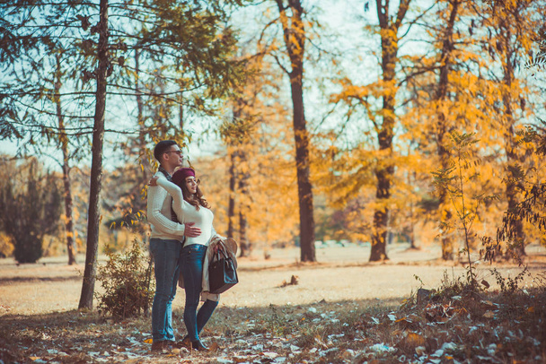 Happy couple spending carefree time in the wood, looking satisfied while hugging each other - Fotografie, Obrázek