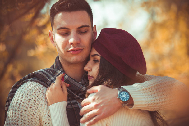 Oszałamiająca para jest spędzać razem jesienny dzień, ciesząc się charakter podczas przytulanie siebie - Zdjęcie, obraz