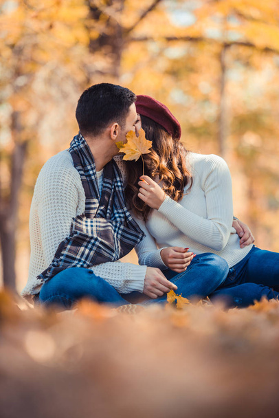 Pretty couple is wearing white, they are spending the day outdoors kissing in the park - Photo, Image