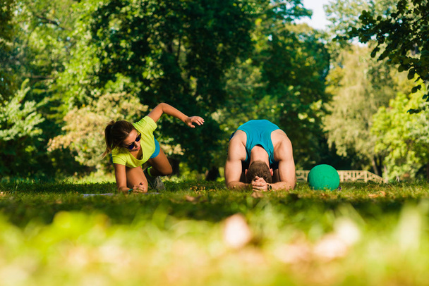 Atraente casal de formação na grama no parque
 - Foto, Imagem