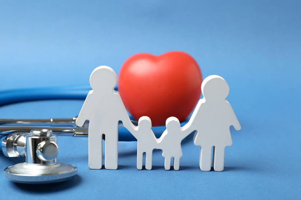 Family figure with stethoscope and heart on color background. Life insurance concept - Fotografie, Obrázek