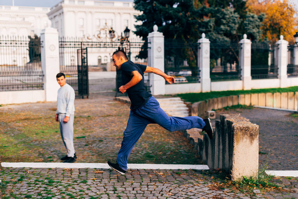 Young man in his 20s doing parkour trick at a public place in the city. - Foto, Imagem