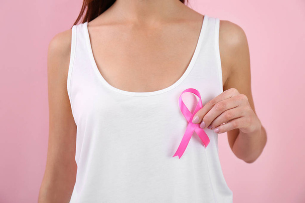 Woman holding pink ribbon on color background, closeup. Breast cancer awareness - Foto, Imagem