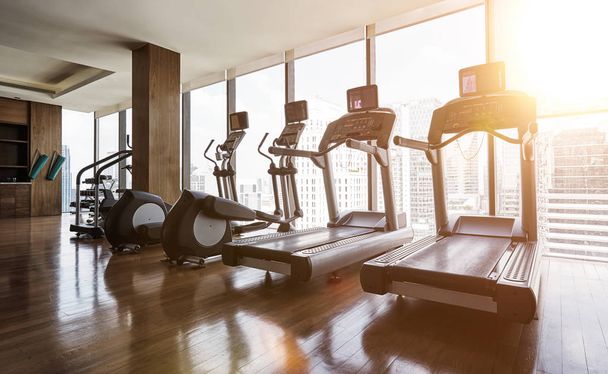 Modern gym room fitness center with set of treadmills staying in line , morning sunrise  scene . - Φωτογραφία, εικόνα
