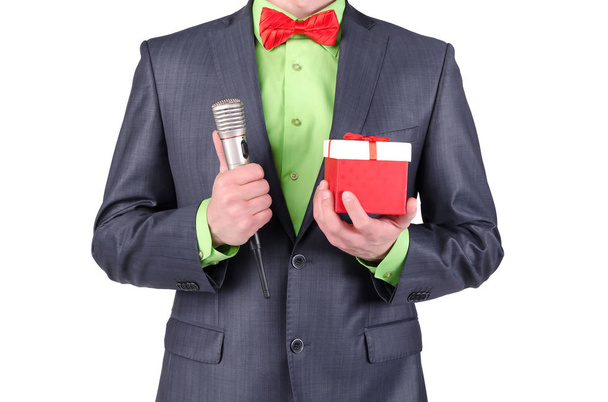 Gift box with a red bow and a radio microphone in a presenter hands on a white background. - Fotoğraf, Görsel