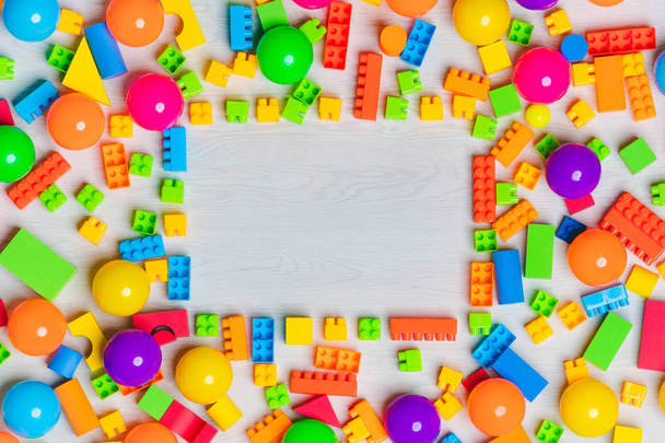 Крупним планом знімок з різнокольорових іграшок, блоків, переплетених лего, дерев'яних цеглин, побудови ігрових фігур дітей організовують іграшки різної форми з копіювальним простором в центрі
 - Фото, зображення