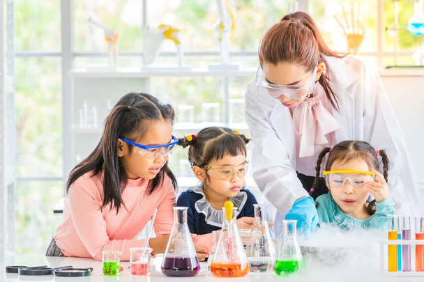 Věda učitel učit asijské studenty v laboratorní místnosti, kouř plovoucí mimo mísu, nadšení, barevné zkumavky a mikroskopu na stole v místnosti laboratoře, koncept pro studium v laboratorní prostor. - Fotografie, Obrázek