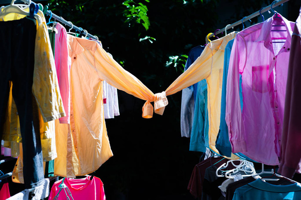 カラフルな濡れた服が太陽の熱によって乾燥のためスチール物干しに掛かっています。シャツの概念の甘いカップル。幸せなバレンタインデー - 写真・画像