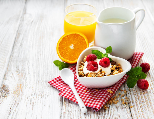Zdravá snídaně, jogurt, čerstvé jahody a müsli na bílý dřevěný stůl - Fotografie, Obrázek