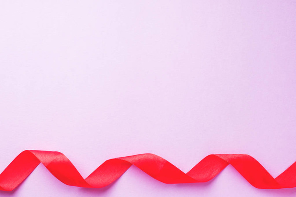 concept Valentine's day, Red ribbon on pink background - Foto, afbeelding