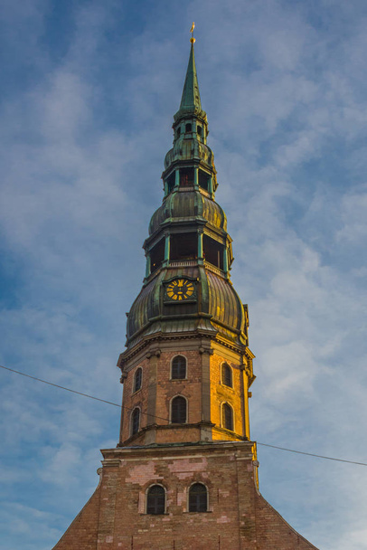 Riga, Latvia: Spire Church of St. Peter is one of the symbols and one of the main sights of the city of Riga. Golden pawn on top St. Peter's Church, Petrikirche - Photo, Image
