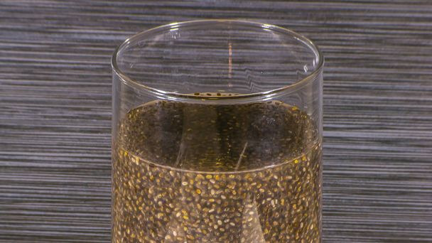 Graines de chia trempées dans l'eau à l'intérieur d'un verre transparent. Vue rapprochée des graines de chia trempées dans l'eau à l'intérieur d'un récipient en verre transparent. Ces graines sont hydrophiles ou peuvent absorber jusqu'à 12 fois son propre poids
. - Photo, image