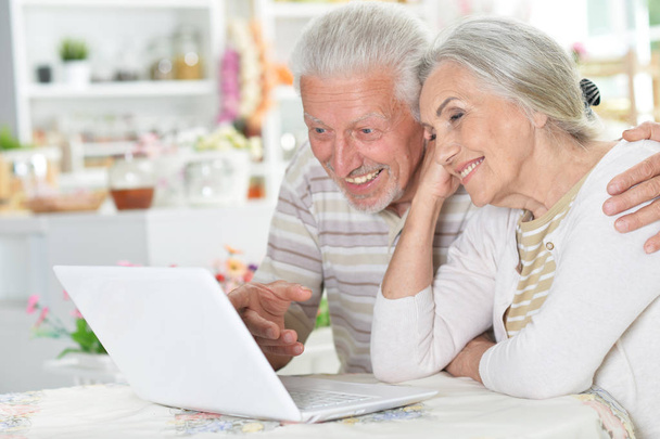 portrait of happy beautiful senior couple using laptop at home - Foto, afbeelding