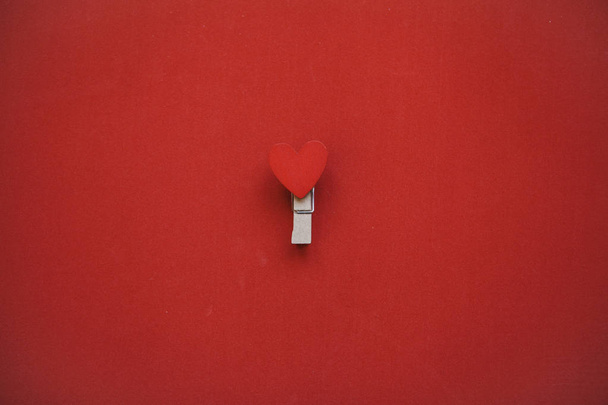 Clothespin with a heart on a red background in a minimal style - Zdjęcie, obraz
