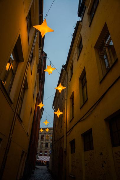 Narrow Rozena street in old town Riga, Latvia with stars garland. Christmas decoration on the european street. Rozena iela - Φωτογραφία, εικόνα