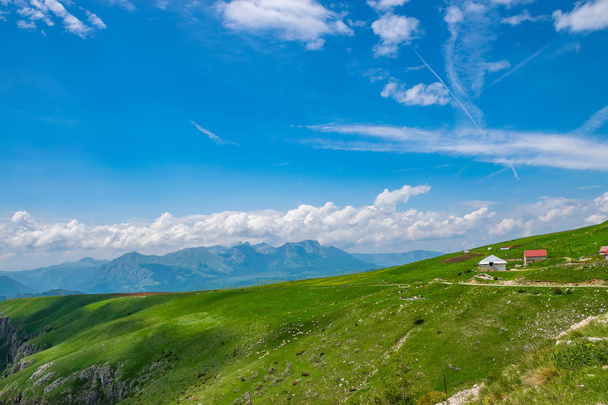 Vista panorámica de pintoresco pueblo entre prados en las altas montañas
 - Foto, imagen