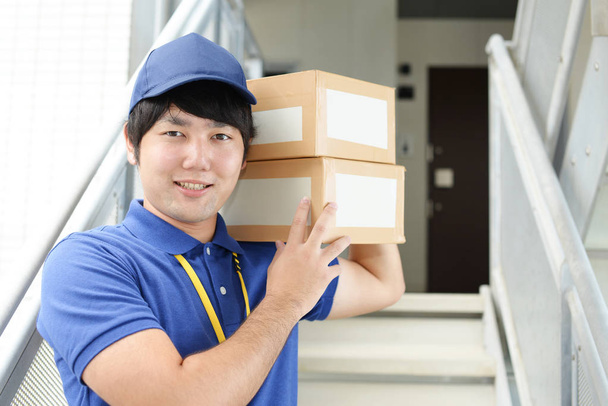 Sorrindo homem de entrega com pacotes
 - Foto, Imagem