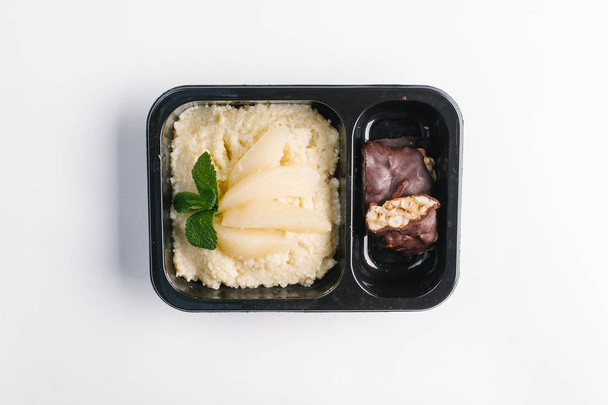 Ansicht von gesundem Essen in schwarzem Plastikbehälter auf weißem Backdrrop  - Foto, Bild
