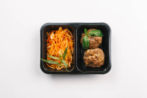 Vue du dessus de la bonne nutrition des boulettes de viande et de légumes salade en boîte sur fond blanc
 - Photo, image