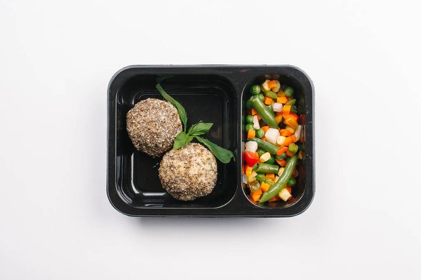 白い背景の胡麻団子と野菜ボックスの適切な栄養のトップ ビュー - 写真・画像