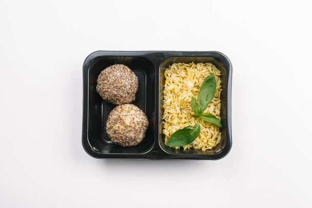 Bovenaanzicht van de juiste voeding van kurkuma rijst en sesam ballen in vak op witte achtergrond - Foto, afbeelding