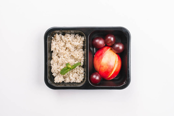 白い背景の大麦とフルーツ ボックスでの適切な栄養のトップ ビュー - 写真・画像
