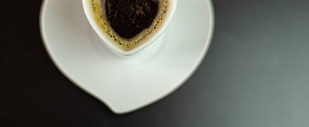Czarna kawa w filiżance ceramiczne na pasku, energia pić w miejscu publicznym, kawiarnia - Zdjęcie, obraz