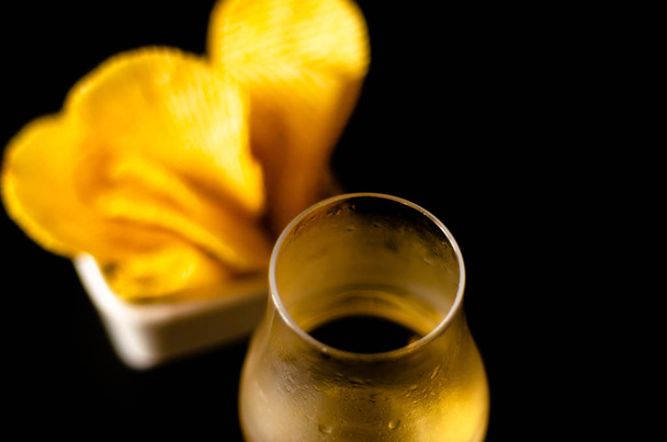 ποτήρι ουίσκι με παγάκια και αλμυρά σνακ στο φόντο της γραμμής, χρόνος συμβαλλόμενων μερών - Φωτογραφία, εικόνα