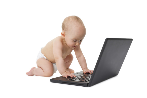 Little baby is playing with a notebook. - Photo, image