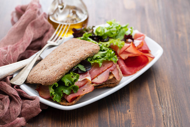 bread with smoked meat and salad on dish - 写真・画像