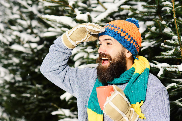 Man wears knitted hat and gloves with happy face. - Foto, Imagen