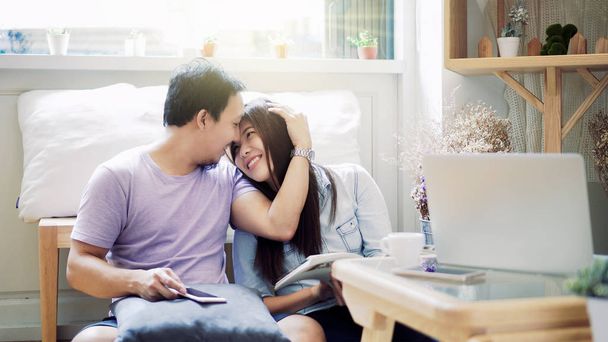 Pari aasialaista rakastajaa istuu yhdessä ja lukee kirjaa aamulla lämpimällä tunteella modernissa työtilassa, elämäntapa ja vapaa-aika rakkauden konseptilla.
 - Valokuva, kuva