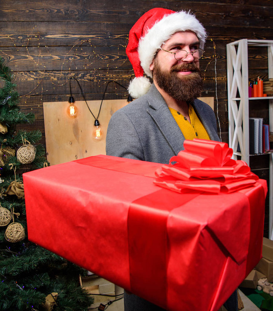 Delivery christmas present. Delivery service. Christmas is coming. Santa courier. Gifts delivery. Man santa hat deliver gift. Spread happiness and joy. Bearded guy with eyeglasses carry present box. - Foto, imagen