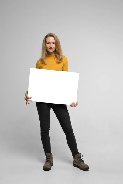 Smiling young woman with poster - Foto, Imagem