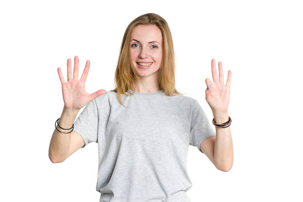 Portrait of a young woman who shows fingers the number eight. - Foto, imagen
