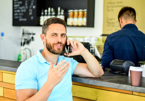 Lets meet in cafe. Man mobile conversation cafe barista background. Drink coffee while waiting. Coffee take away option for busy people. Man with smartphone order coffee. Coffee break concept - Foto, Imagen