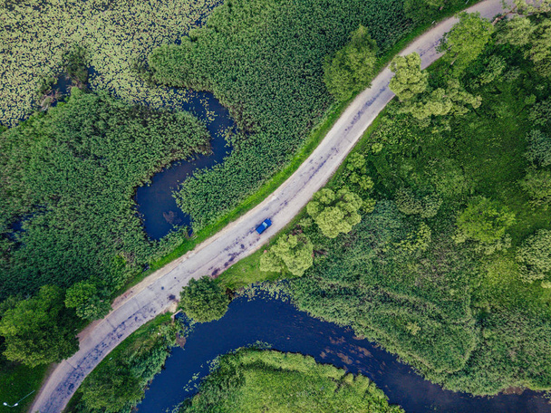 Aerial Photo of Car Driving on the Road going by the River under the Trees, Top Down View in Early Spring on Sunny Day - Concept of Peaceful Life in Countryside in Harmony and Traveling, Freedom - Photo, Image