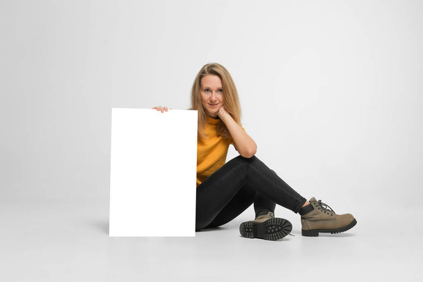 vrouw zitten met plakkaat - Foto, afbeelding