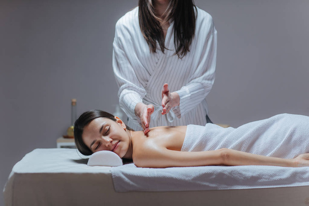 Young woman enjoying a back massage in a spa center. - Foto, Bild