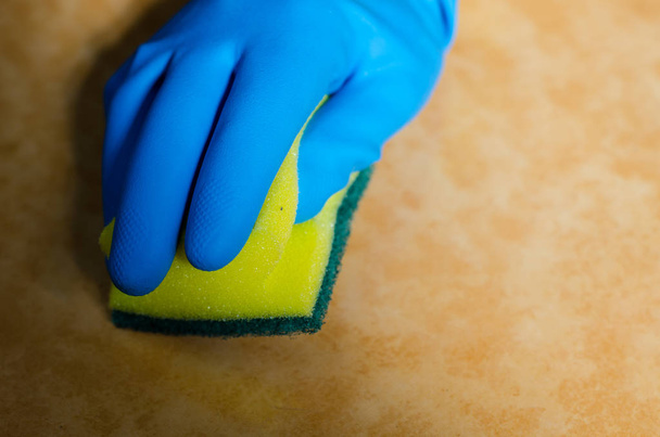 руки в резиновых перчатках для очистки поверхностей керамической плитки, безопасной и гигиеничной очистки, поддержания чистоты дома
 - Фото, изображение