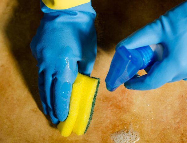 hands in rubber gloves cleaning the surfaces of ceramic tiles, safe and hygienic cleaning, keeping the house clean - Photo, Image