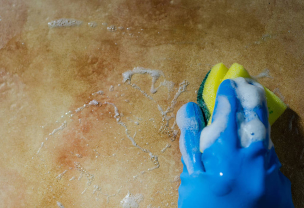 τα χέρια σε λαστιχένια γάντια καθαρισμού των επιφανειών από κεραμικά πλακίδια, ασφαλή και υγιεινή καθαριότητα, κρατώντας το σπίτι καθαρό - Φωτογραφία, εικόνα