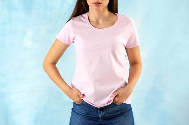Young woman in stylish t-shirt on light background - Фото, изображение