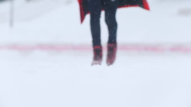 Eine junge Frau eisläuft draußen in knallroten Schlittschuhen. Schneetreiben - Filmmaterial, Video