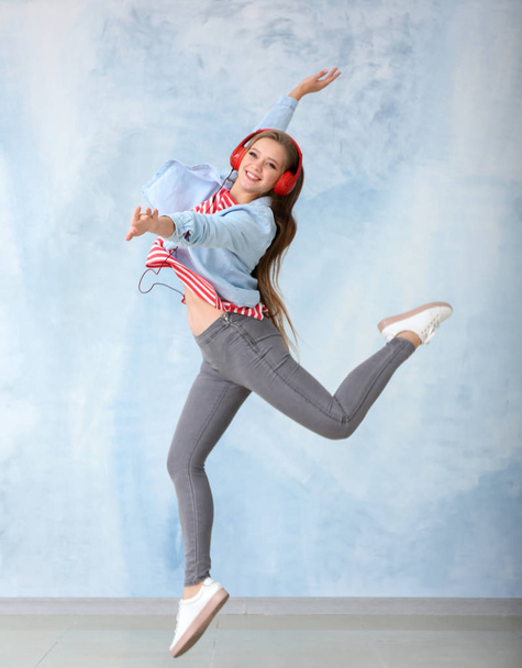 Hermosa joven bailando cerca de la pared de color
 - Foto, Imagen